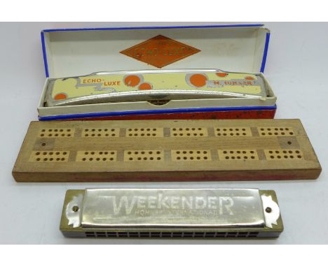 Two Hohner harmonicas, one boxed and a cribbage board 