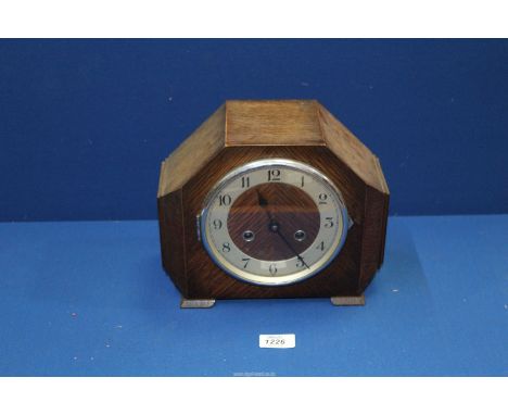 An oak two train Art Deco style Mantle Clock having Arabic numerals with pendulum and key, 10" wide x 8 1/4" high.