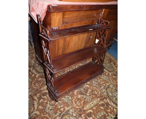 A three tier Mahogany wall Shelf having geometrically fretworked side supports and three blind fretwork detailed trinket draw