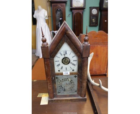 An eight day Mantle clock with Roman numerals and central dial in brass (with Roman numerals), lower section of door having a