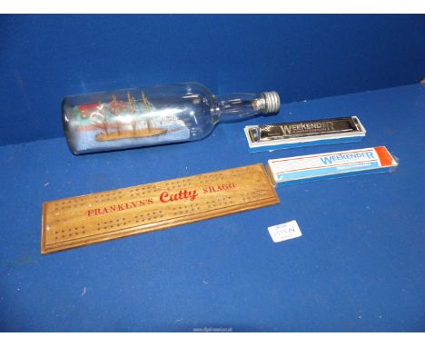 A 1930's folk art diorama ship in a bottle, a 'Franklyn's Cutty Shag Tobacco' cribbage board and a 'Weekender Hohner Tremelo'