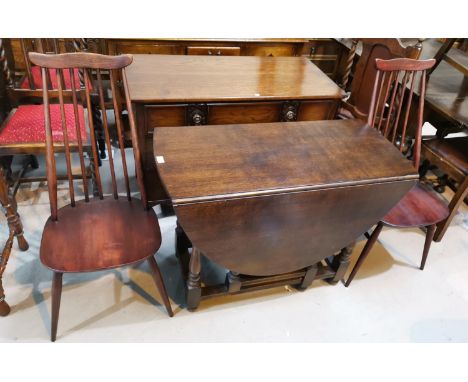 An oak drop leaf dining table with oval top, on gate legs; a set of 4 Ercol style stick back chairs 