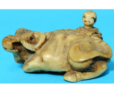 A Meiji period netsuke depicting a boy with recumbent buffalo, signature to base 