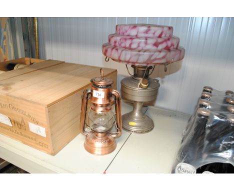An oil lamp with mottled glass shade and candle lantern