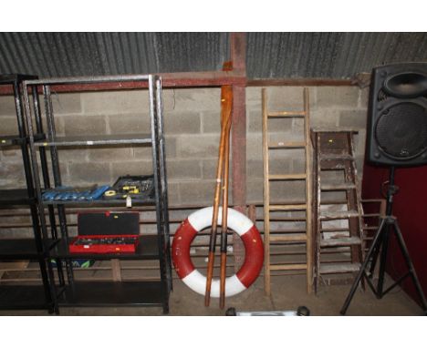 A pair of wooden rowing oars and a Perry Buoy life ring