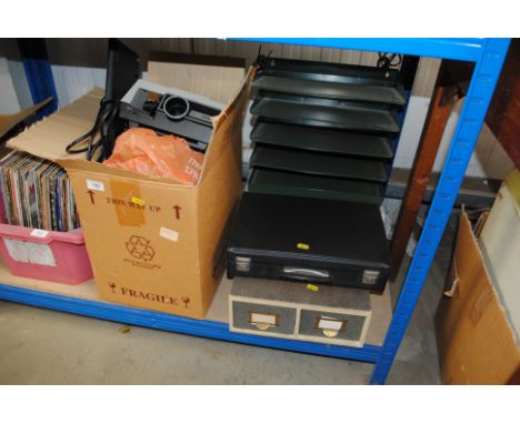 A box containing a projector, keyboard, boxes and filing tray