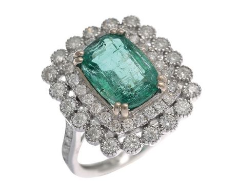 AN EMERALD AND DIAMOND CLUSTER RING Centrally set with a cushion cut emerald... AN EMERALD AND DIAMOND CLUSTER RING Centrally