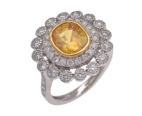 A SAPPHIRE AND DIAMOND RING Of cluster design A SAPPHIRE AND DIAMOND RING Of cluster design, the cushion cut golden sapphire 