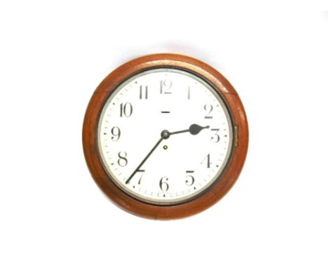 A SCHOOL WALL CLOCK circa 1910, the circular white dial with black Arabic numerals, within an oak surround, overall 38cm diam