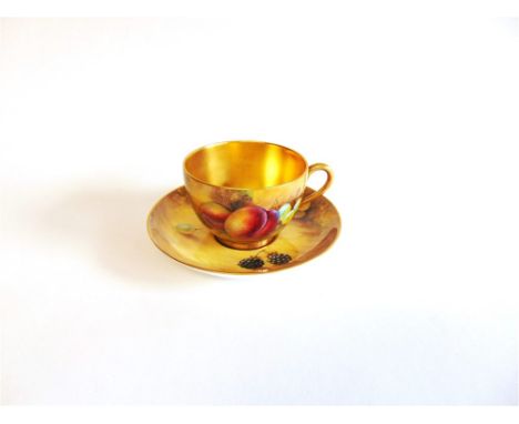 A ROYAL WORCESTER CUP AND SAUCER  with painted decoration of fruit signed 'J Smith', the cup with gilt interior, the saucer 1