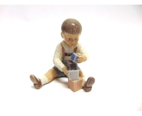 A DAHL JENSEN COPENHAGEN PORCELAIN FIGURE  modelled as a young boy playing with building blocks, marked to base '1167', and a