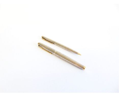 A PARKER BALL POINT PEN AND PROPELLING PENCIL SET stamped 'Sterling Silver', with all over engine turned decoration with gilt