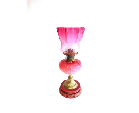 A VICTORIAN OIL LAMP,  the cranberry glass shade with etched decoration, opaque pink glass reservoir on brass column and cera