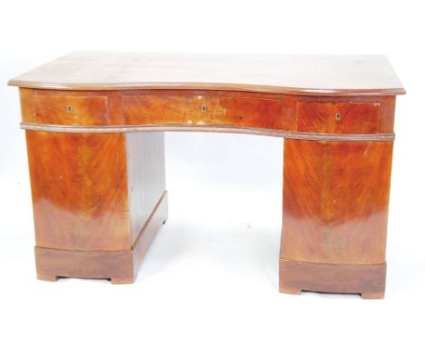 TWENTIETH CENTURY GEORGIAN STYLE MAHOGANY YOKE FRONTED TWIN PEDESTAL DESK, the shaped polished top above three flame cut frie