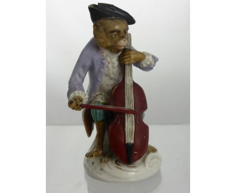 A Continental Porcelain Monkey, depicted playing a cello, with blue crossed mark to the base, approx 11 cms.