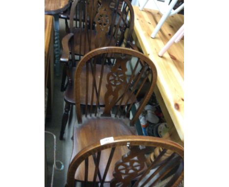 A set of four stick and wheel back dining chairs, two standards, two elbows