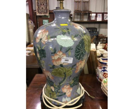 An Oriental baluster table lamp having foliate decoration on carved stand