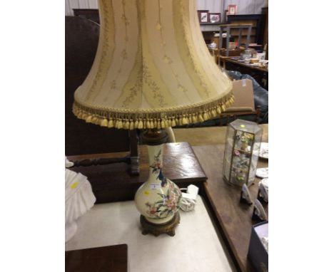 A porcelain and brass mounted table lamp decorated with birds amongst foliage