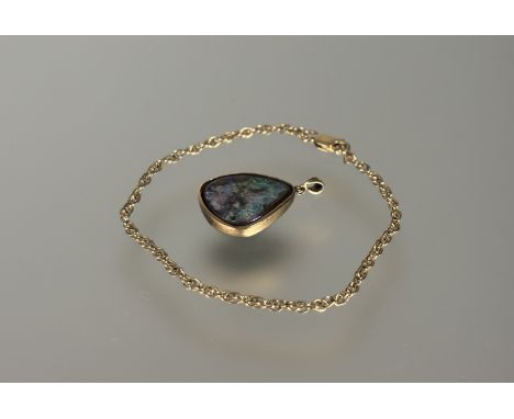 An  Australian orange and green fire opal nugget pendant in 9ct gold rub over mount: h. x 2cm and a 9ct chain link bracelet w