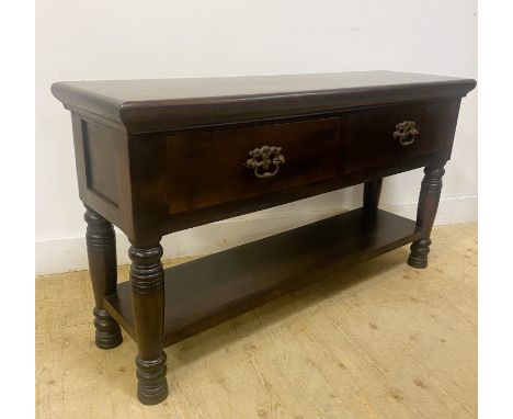 A dark teak side cabinet, with a rectangular top above two drawers with a shelf below, standing on turned supports, 76.5cm x 
