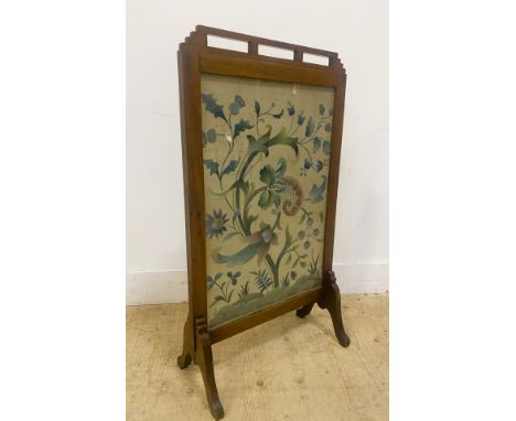 A mahogany fire screen, with a shaped and pierced top above a floral needlework panel, standing on shaped splayed supports, 9