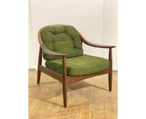 A 1960's Greaves and Thomas teak armchair, with a shaped stick back and swept arms, with a loose back and seat cushion, stand