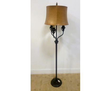 A black metal standard lamp, raised on a circular domed base and column, with three shaped arms and a faux ostrich shade, 174