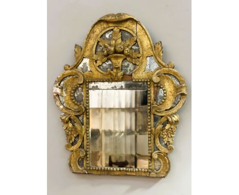 An 18th century Italian giltwood mirror in the Baroque taste, the (distressed) rectangular plate within a mirror-inset frame 