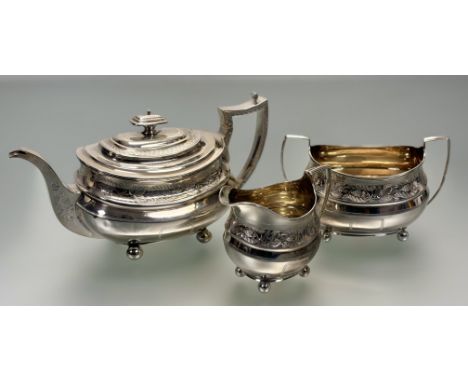 A George III composed three piece silver tea service, in the Regency taste, each piece of oval bellied form engraved with ban