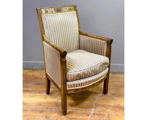 A 19thc Continental oak-framed bergere with relief carved acanthus top rail and arms, upholstered in chain link satinised cot