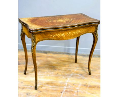 An early 20th century serpentine marquetry inlaid foldover card table in the French taste, with swivel top and baize lined in