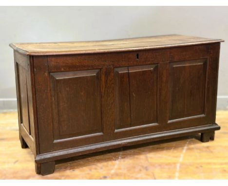 An early 19thc oak triple panel fronted coffer with hinged plank top, on shaped stile supports, plain interior (h.66cm x l.12