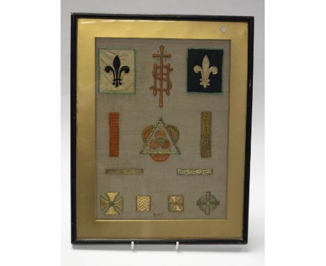 A first half 20th century sampler, silver, gold and coloured thread depicting fleurs-de-lys (Scouts?), in a black ebonised fr