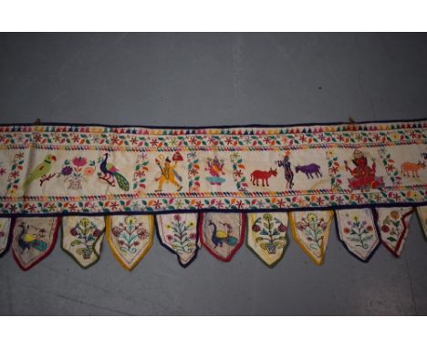 Two Rajasthan torans, north India, circa 1940s-50s, the first, 178in. X 20in.(including the lappets) 453cm. X 51cm., embroide