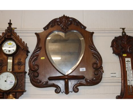 An Edwardian carved mahogany mirrored wall shelf 