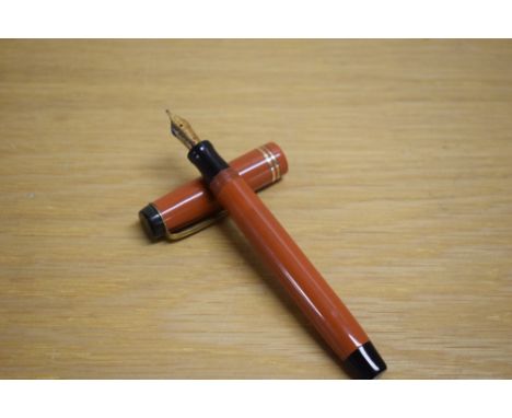 A Parker Duofold Junior button fill fountain pen in orange with two gold bands to the cap having Parker 14KEngland 25 4 nib.