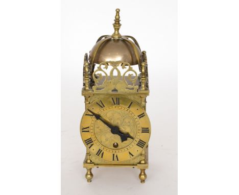 A 20th Century brass lantern clock, Roman numerals to a circular dial below pierced stylised dolphin fret work and dome bell,