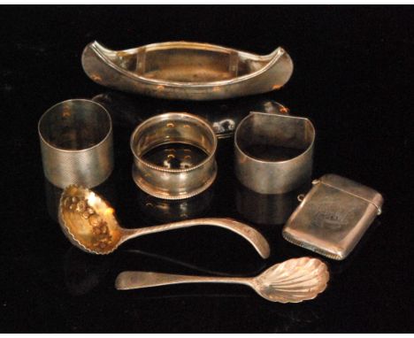 A small parcel lot of assorted silver items to include model of a canoe, three silver napkin rings, a vesta case, a ladle and