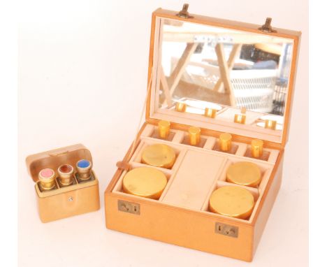 A 1940s light brown leather make up case with fitted interior together with a leather cased set of three scent bottles and sm