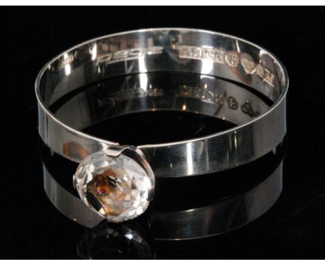 A 1960s Swedish silver bangle, the plain circular tapered bangle united by a large facet cut quartz crystal in a  four claw s