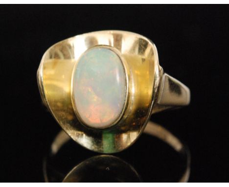 A modern 15ct opal ring, central oval collar set opal within a cupped and shaped triangular border, forked shoulders to plain