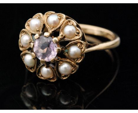 A 9ct hallmarked amethyst and split pearl circular cluster ring, central amethyst within an eight stone pearl surround, ring 