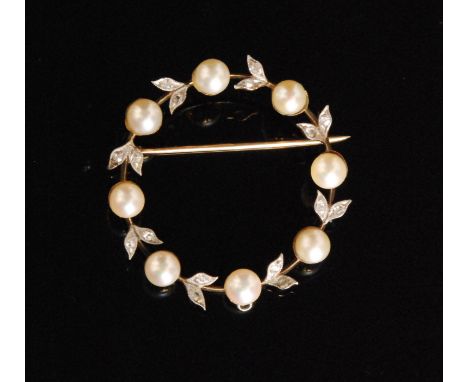 A diamond and pearl circular wreath brooch set with eight cultured pearls each spaced by rose cut millegrain set diamond leav