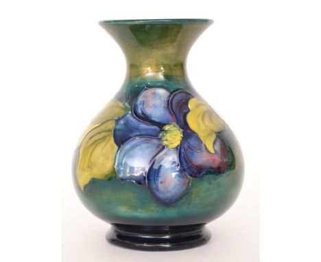A Moorcroft vase of globe and shaft form decorated in the Clematis pattern with tubelined flowers and foliage against a green
