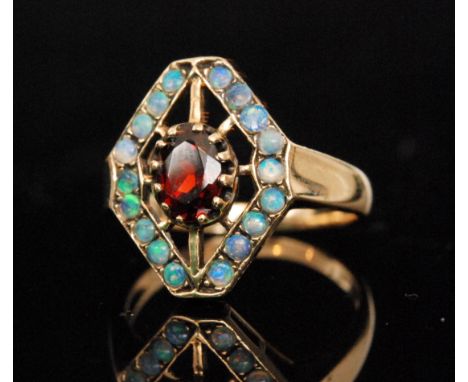 A mid 20th Century 9ct garnet and opal cluster ring, central claw set oval garnet within a pierced head and opal set border, 