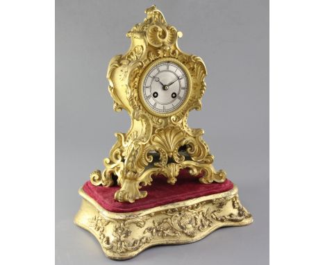 A mid 19th century French ormolu mantel clock and stand, the cartouche case raised on a giltwood stand, the 3.75 inch silvere