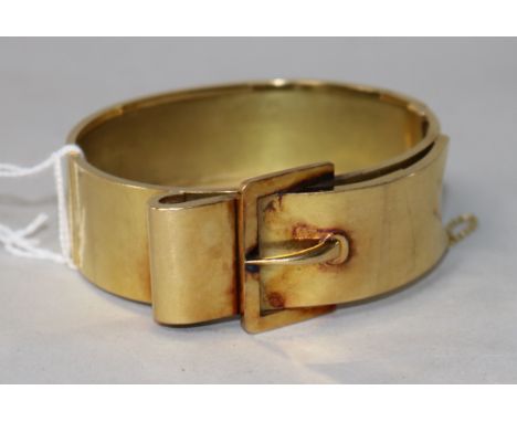 An early 20th century yellow metal "buckle" design hinged bangle.