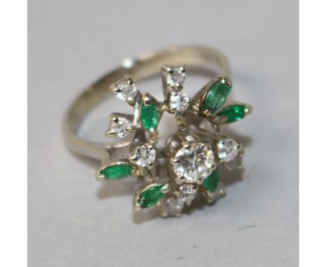 An 18k white gold, emerald and diamond cluster dress ring, size O.