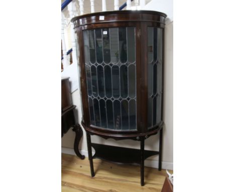 A 1920's mahogany bow fronted display cabinet, enclosed by a glazed leaded door 99cm.