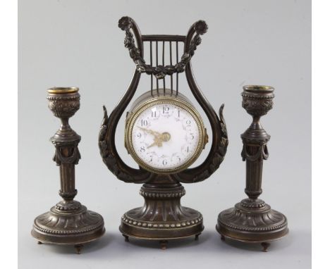 An early 20th century French patinated bronze garniture, the timepiece in lyre case, with 2.25 inch Arabic enamel dial, the s